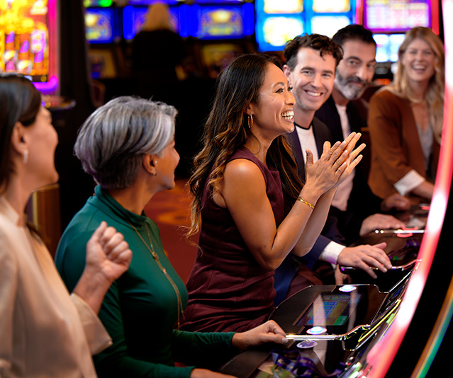 Group of people sitting at slot machines.